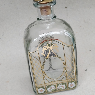 Snapseflaske med guld og hvide dekorationer malet på klar flaske fra Holmegaard