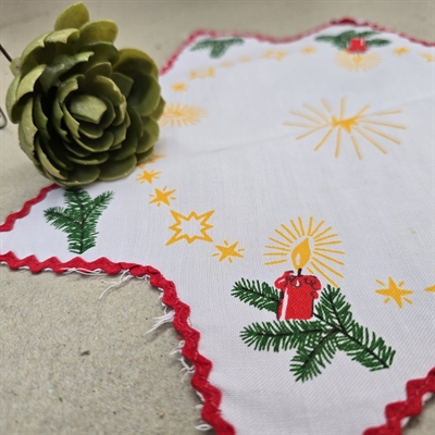 hvid-stjerneformet-lysedug-rød-sik-sak-kant-printede-grangrene-med-lys-på-gammel-juletekstil