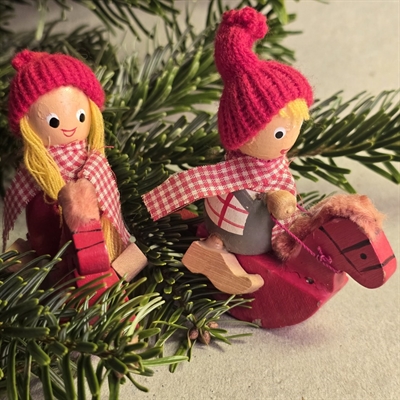 nissepige-nissedreng-med-ternede-toerklaeder-paa-roede-trae-gyngeheste-gammel-julepynt-