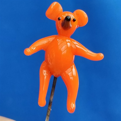 Orange bamse med sorte øje og snude, gammel glas nipsenål.