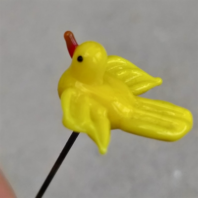 Gammel glas nipsenåle, som forestiller en gul fugl med rødt næb. 