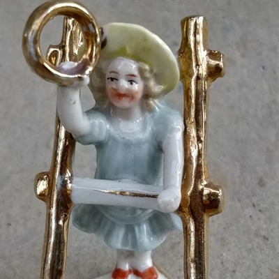 pige-lyseblå-kjole-guldring-i-hånden-ved-stige-stående-på-hjerte-gammel-porcelænsfigur