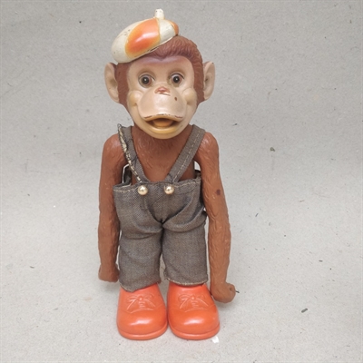 stående-brun-abekat-grå-overalls-røde-sko-kasket-gammel-