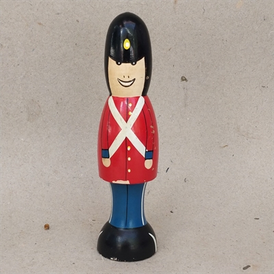 sort-bjørneskindshue-rød-jakke-blå-bukse-træ-garder-gammelt-legetøj