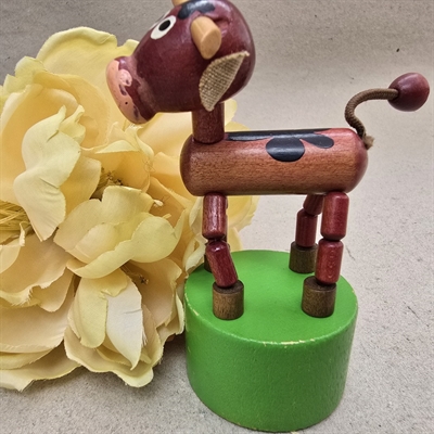 brun-traeko-med-sorte-aftegninger-staar-paa-groen-trykknap