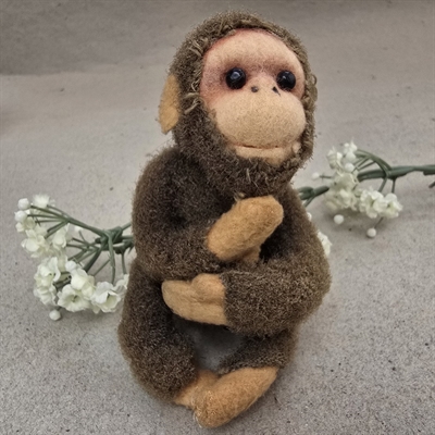 brun-plys-abe-hudfarvet-haender-hoved-foedder-gammelt-krammedyr