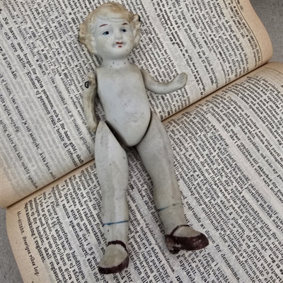 porcelænsdukke-kroellet-haar-blaa-sloejfe-sorte-sko-antik-dukke