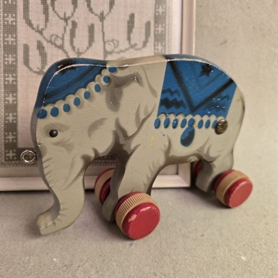 graa-blaa-elefant-trae-paa-roede-hjul-gammelt-traelegetoej-traekdyr