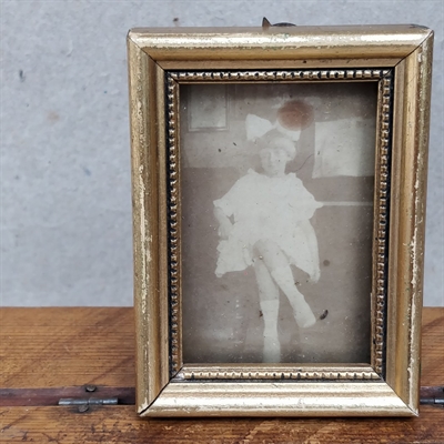 hvid-kjole-stor-sløjfe-håret-pige-gammelt-foto-guld-fotoramme