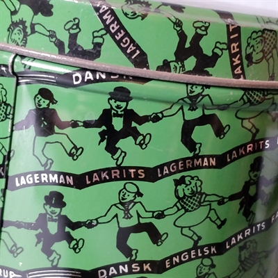 grøn med dansende sorte figurer på rund stor dåse i metal fra Lagerman lakrids genbrug