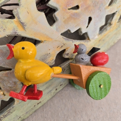 trae-gul-aelling-roedt-naeb-foedder-traekker-traevogn-groenne-hjul-blå-kylling-roedt-aeg-i-traekvognen-gammelt-paaskepynt