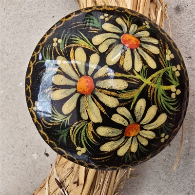 rund-letbuet-træbroche-hvide-blomster-gron-dekoration-sort-bund-gammel-broche-fransk