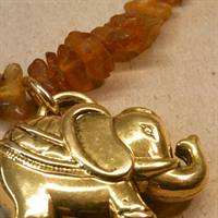 Rårav kæde med guldfarvet elefant som vedhæng. 
