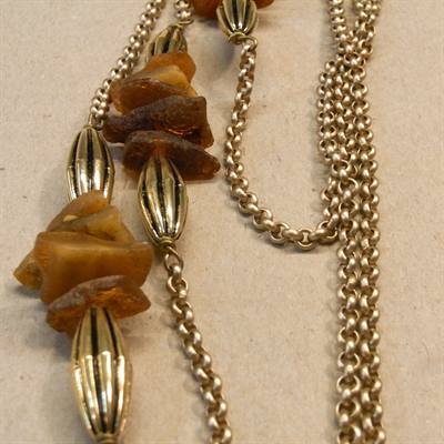 Halskæde med guldfarvede perler og rå rav.