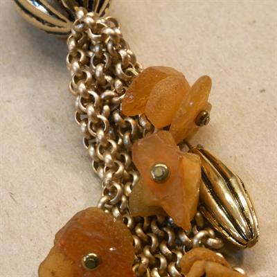 Guldfarvet kæde med rå rav stykker forenden på guldfarvet kæde.