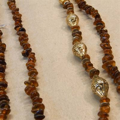 Mørk trumlepoleret lang rav halskæde med guldfarvede perler. 158 cm